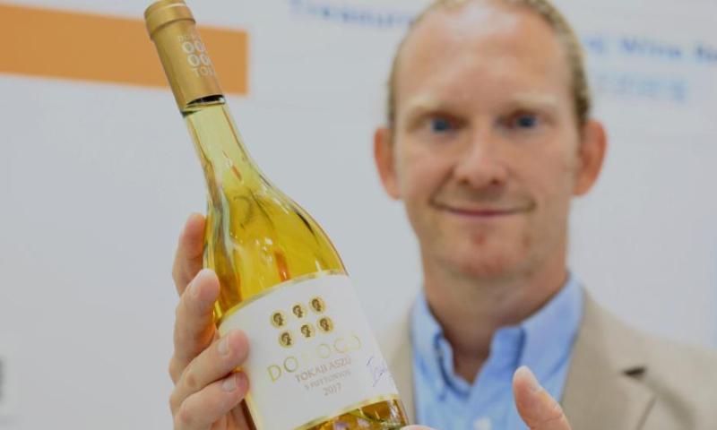 A wine merchant from Hungary displays a bottle of wine produced in Hungary's Tokaj wine area during the 24th China International Fair for Investment and Trade (CIFIT) in Xiamen, southeast China's Fujian Province, Sept. 8, 2024. Covering around 120,000 square meters, the four-day CIFIT opened here on Sunday and draws visitors from 119 countries and regions, of which about 80 percent are Belt and Road Initiative (BRI) partner countries. This year's CIFIT highlights the digital economy, new energy and green innovation. It is expected to serve as a platform for more than 80 investment events and roadshow activities. (Xinhua/Wei Peiquan)