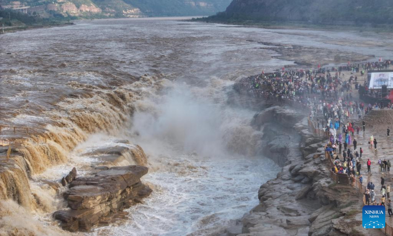 An aerial drone photo taken on Oct. 4, 2024 shows tourists visiting the Hukou Waterfall on the Yellow River, on the border area between north China's Shanxi and northwest China's Shaanxi provinces. (Xinhua/Chen Yehua)