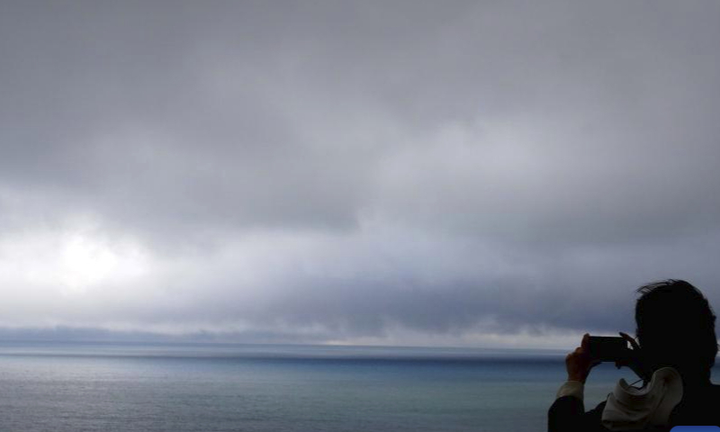 A tourist takes photos at Sayram Lake in Bortala Mongolian Autonomous Prefecture, northwest China's Xinjiang Uygur Autonomous Region, Sept. 26, 2024. Sayram Lake is the largest and highest alpine lake in Xinjiang. (Xinhua/Zhao Yusi)

