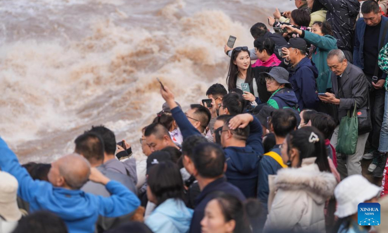 Tourists visit the Hukou Waterfall on the Yellow River, on the border area between north China's Shanxi and northwest China's Shaanxi provinces, on Oct. 4, 2024. (Xinhua/Chen Yehua)