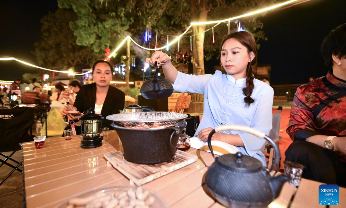 Tourists and local residents prepare to taste tea in Liubao township, in Cangwu county of Wuzhou, south China's Guangxi Zhuang Autonomous Region, March 25, 2024. Liubao tea, a Chinese dark tea characterized by its strong and lingering fragrance and medical effects, boasts a history of more than 1,500 years. Famous for Liubao tea making, the city of Wuzhou has over 400,050 mu (about 26,670 hectares) of tea plantations, with an output value exceeding 20 billion yuan (about 2.8 billion dollars). (Photo: Xinhua)