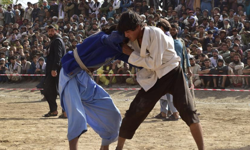 This photo taken on Sept. 8, 2024 shows people participating in a traditional wrestling contest in Nahrin district, north Afghanistan's Baghlan province. Wrestling, a traditional sport with deep roots in Afghan culture, remains popular across the country. In Baghlan province, wrestlers from Baghlan, Kunduz, Takhar and Samangan provinces competed in a thrilling tournament. Dozens of athletes participated, with thousands of spectators gathering to attentively witness this time-honored sport. (Photo by Mehrabuddin Ibrahimi/Xinhua)