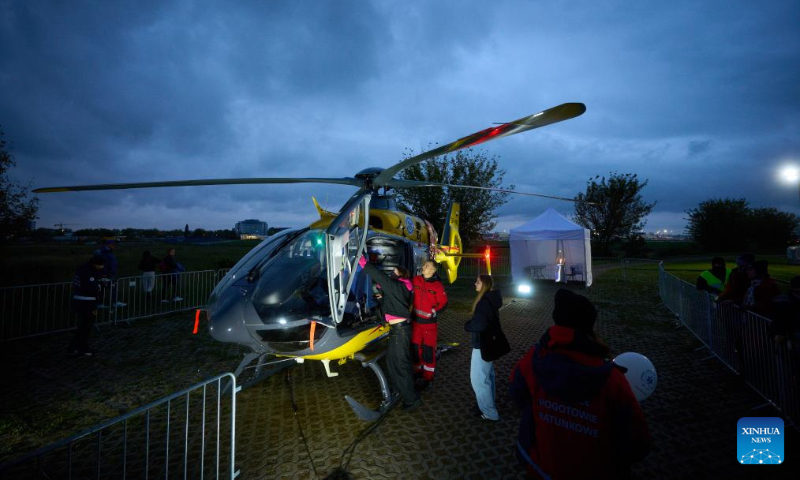 Visitors observe a medical helicopter at the 13th Night at the Institute of Aviation in Warsaw, Poland on Oct. 4, 2024. This annual event, hosted by the Warsaw Institute of Aviation, is one of the largest educational night activities in the country, aimed at promoting knowledge and careers in aviation and engineering. (Photo by Jaap Arriens/Xinhua)