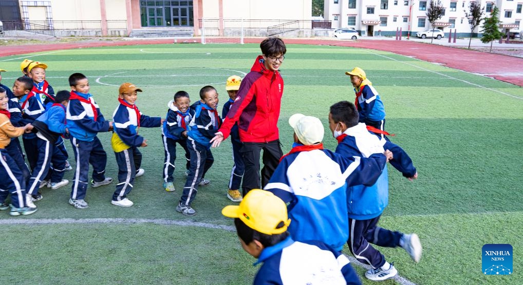 A volunteer teacher from Lingnan Normal University in Guangdong plays with students at the Central Primary School in Nyangpo Township, Gongbo'Gyamda County, Nyingchi City, southwest China's Xizang Autonomous Region, Sept. 3, 2024. (Photo: Xinhua)