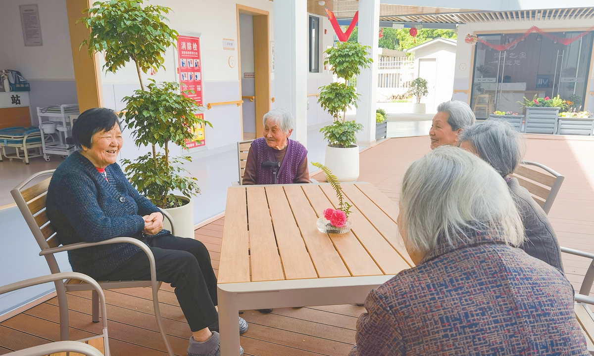 Senior residents chat in the yard of 