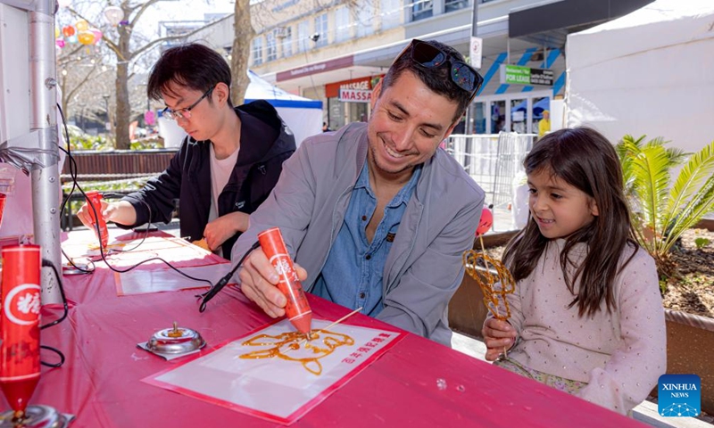 A man and his daughter make sugar painting during a celebration of the upcoming Mid-Autumn Festival in Canberra, Australia, Sept. 7, 2024. Photo: Xinhua