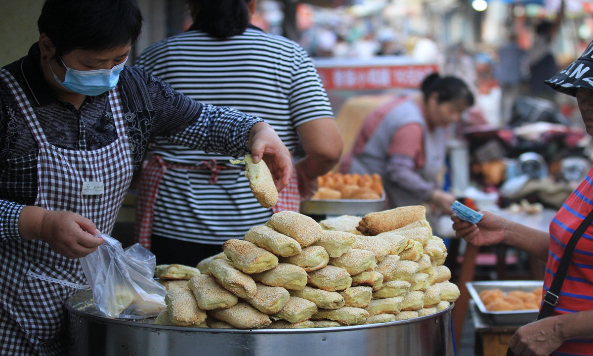 A shopkeeper prepares local snacks for people strolling along a time-honored old street for breakfast in Huai'an, East China's Jiangsu Province on September 8, 2024. The catering industry in Jiangsu saw robust growth in the first seven months of the year, with major catering companies posting revenue growth of 9.6 percent year-on-year. Photo: VCG