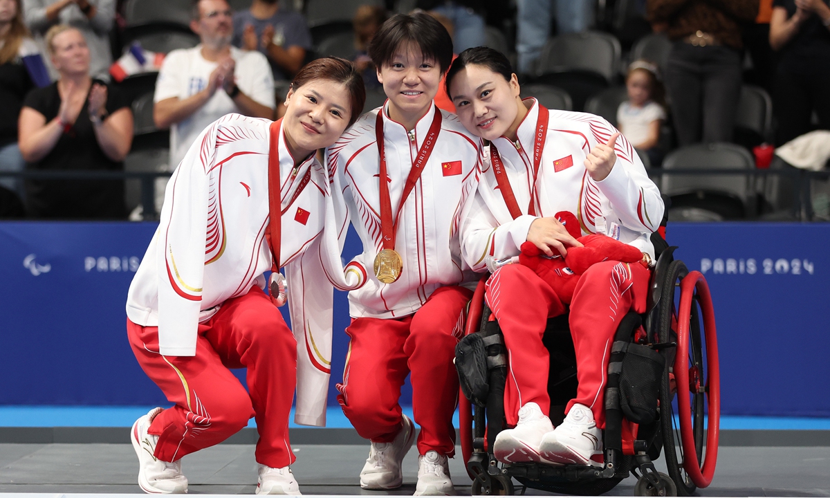 Gold medalist He Shenggao (center), silver medalist Lu Dong (left), and bronze medalist Cheng Jiao pose for a photo after the women's 200m individual medley - SM5 swimming event at the Paris Paralympics on September 7, 2024.  Photo: VCG