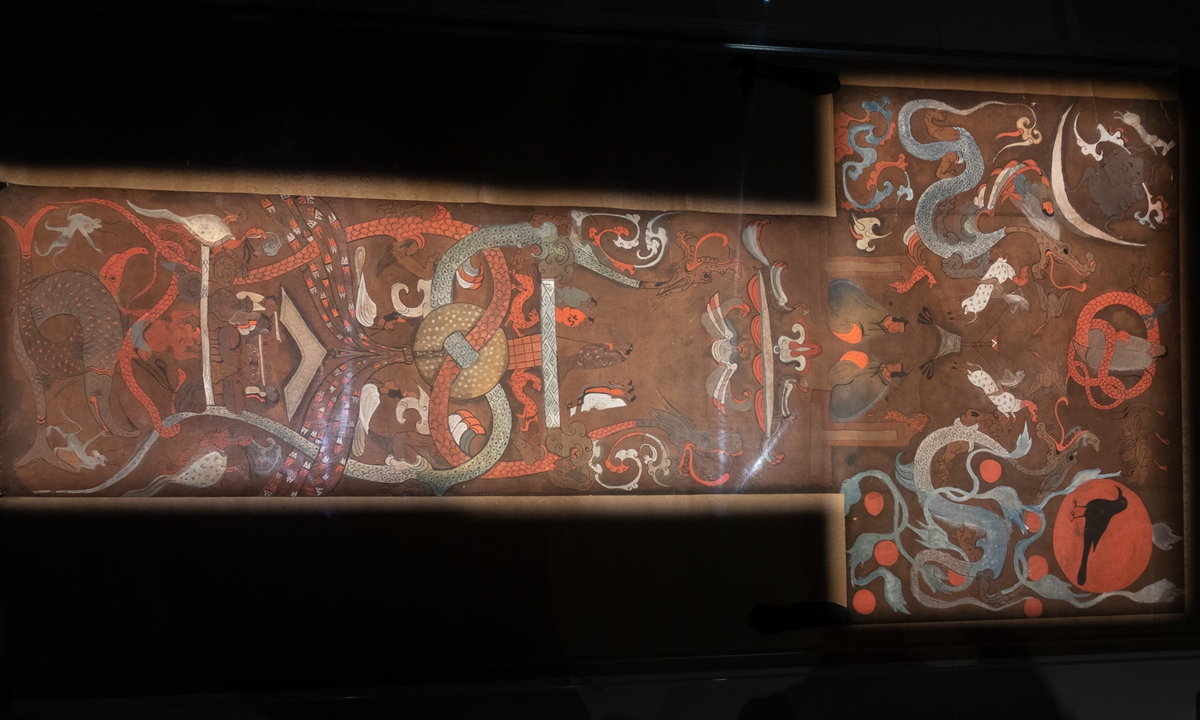 T-shaped painting on silk:
The<strong></strong> T-shaped silk painting, 205 centimeters long, was a banner carried at the front in the funeral procession, and it was then laid on the innermost coffin at the burial. With the ink drawing and heavy-colored drawing techniques, the painting is divided into the heavenly world, the human world and the underworld from the top to the bottom.