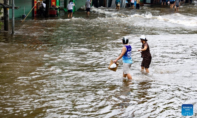 People wade through water on a street in Hanoi, capital of Vietnam, Sept. 10, 2024. Super typhoon Yagi and its subsequent floods and landslides in Vietnam's northern region have claimed at least 82 lives as of Tuesday early afternoon while 64 others remain missing, said the country's Ministry of Agriculture and Rural Development. (Photo: Xinhua)