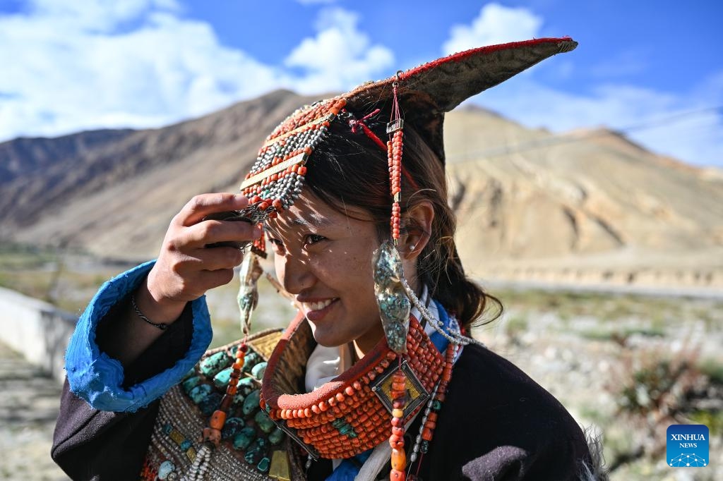 A villager displays folk costume in Kejia Village of Pulan County, southwest China's Xizang Autonomous Region, Sept. 9, 2024. Originating in Pulan County, Pulan folk costume has been a traditional garment worn at celebrations for over a millennium. Weighing more than 20 kilograms, a piece of this unique costume is usually decorated with rare metals and jewels, like gold, silver, beeswax, coral and turquoise. (Photo: Xinhua)