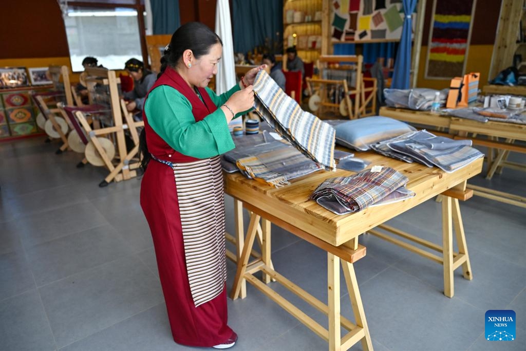 A craftswoman arranges cashmere pulu, a kind of Tibetan woolen fabric, at a workshop in Gyangze County, southwest China's Xizang Autonomous Region, Sept. 3, 2024. Pulu is a traditional woolen fabric and the primary material Tibetans use to make clothes. With the support of a paired-up assistance program, the pulu weaving industry in Gyangze County has been revitalized. (Photo: Xinhua)