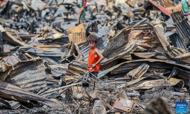 A boy is seen as he searches for useful stuff from his charred home a day after a slum area fire in Cavite Province, the Philippines on Sept. 11, 2024. (Photo: Xinhua)