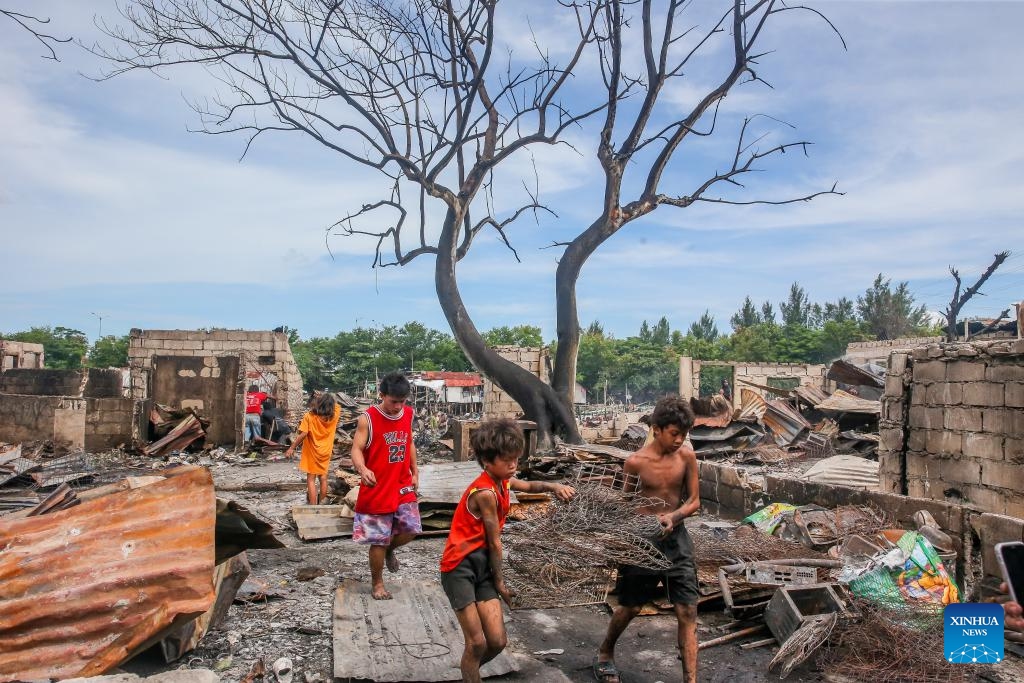 Residents search for useful stuff as they return to their charred homes a day after a slum area fire in Cavite Province, the Philippines on Sept. 11, 2024. (Photo: Xinhua)