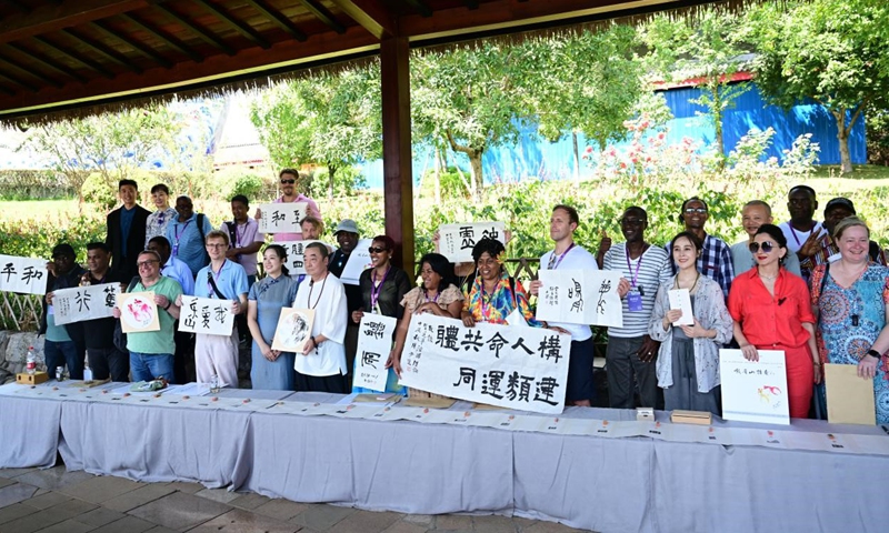 Media representatives participating in the 2024 Media Cooperation Forum on Belt and Road and artists from Emeishan city show artworks co-created by them. (Photo/Chen Chun'an)