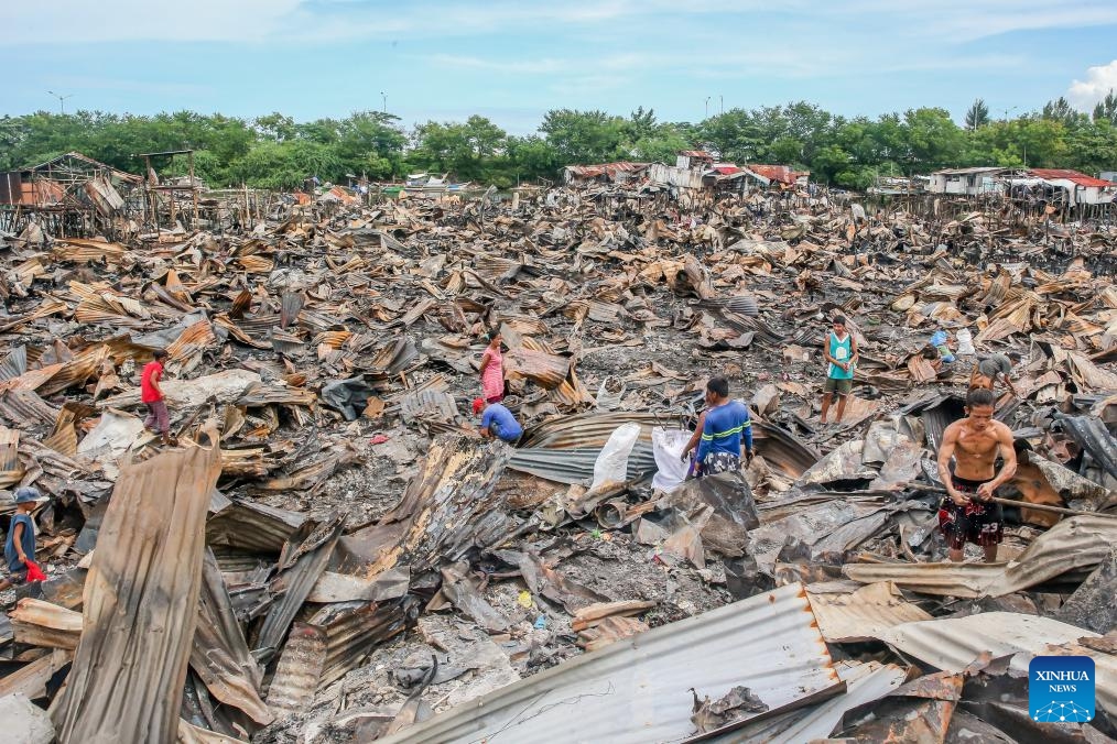 Residents search for useful stuff as they return to their charred homes a day after a slum area fire in Cavite Province, the Philippines on Sept. 11, 2024. (Photo: Xinhua)