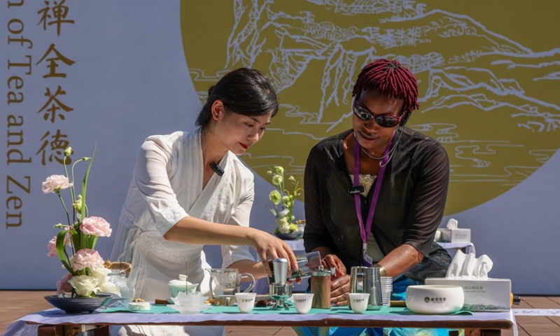 Agnes Mbithe Mwangangi (right), an editor with Kenya Broadcasting Corporation (KBC), and Yang Mei, a Chinese tea artist, demonstrate the skills of coffee brewing and tea making. (People's Daily/Yi Xiao)