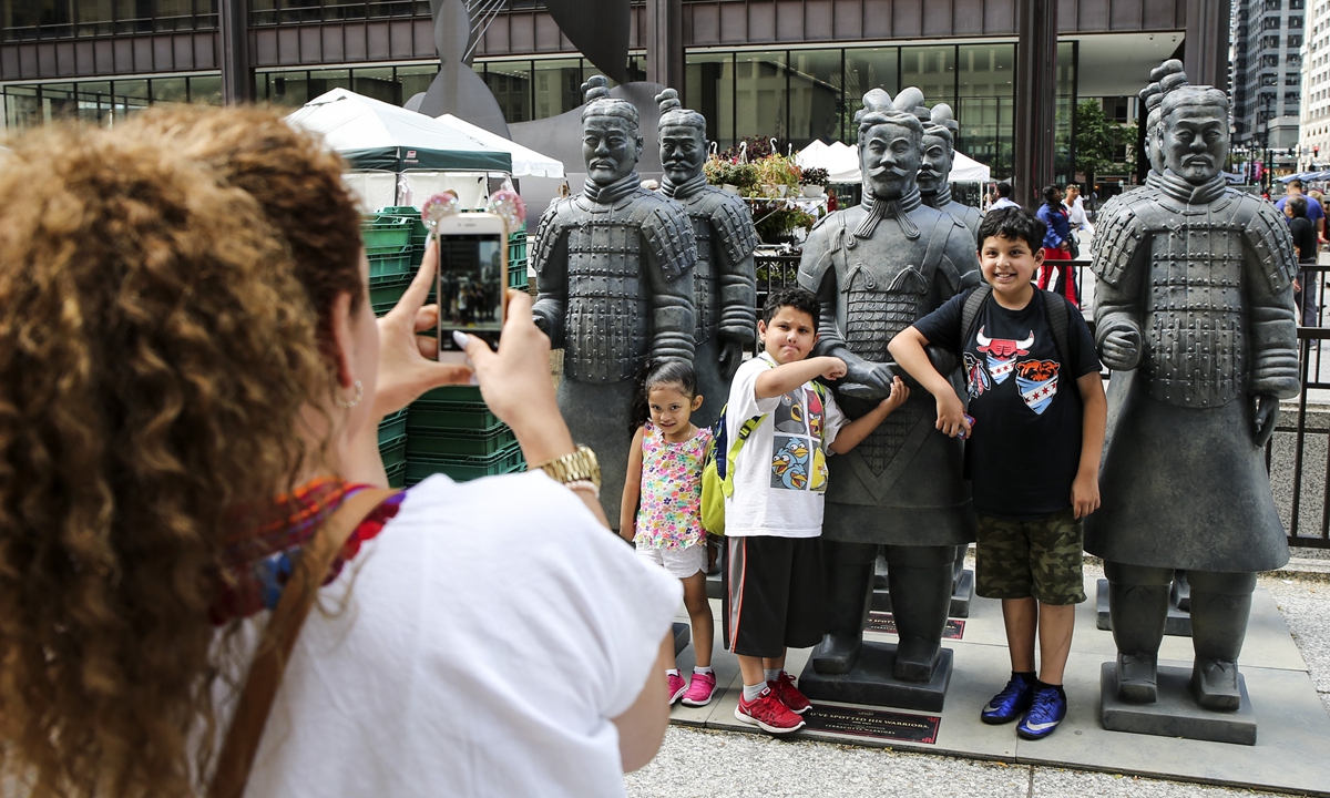 People take photo with replicas of terracotta warriors in Chicago, the US, on July 14, 2016, during the exhibition of ten original terracotta warriors at the Field Museum from July 2016 to January 2017. Photo: VCG