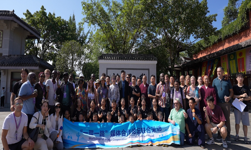 Media representatives participating in the 2024 Media Cooperation Forum on Belt and Road pose for a picture with martial arts trainers and trainees from the Emei Kung-Fu Alliance. (Photo/Chen Chun'an)