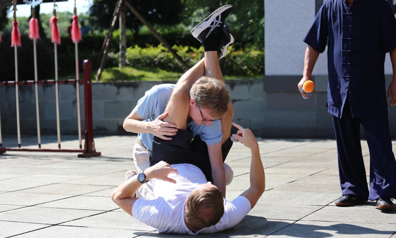 Per Markus Andersson, an editor with The Nordic Times, Sweden, lies on the ground during a demonstration of submission grappling. (Photo/Liu Xiaoli)