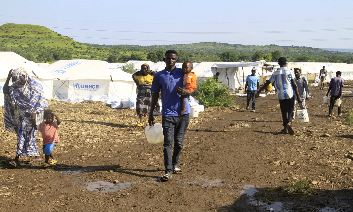 Displaced Sudanese who have returned from Ethiopia, carry gallons of water in a camp run by the United Nations Refugee Agency (UNHCR) in Sudan's border town of Gallabat in the eastern state of Gadaref on September 11, 2024. Ebrahim Hamid /AFP