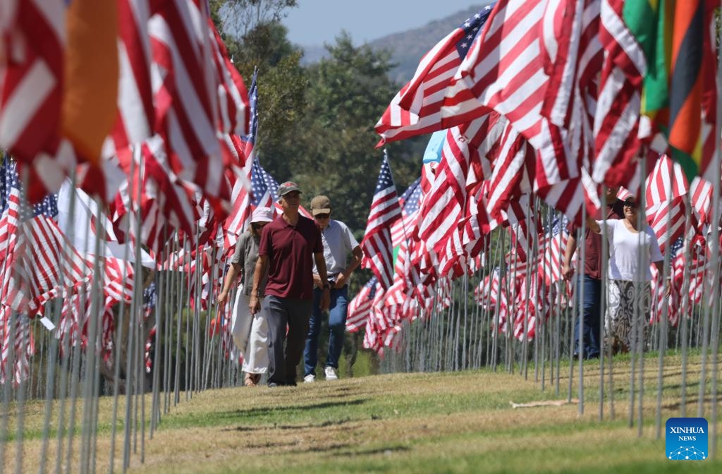 People walk among the Waves of Flags at Pepperdine University in Malibu, California, the United States, on Sept. 10, 2024. Each September, the university stages the Waves of Flags display to honor the victims of the 9/11 attacks. (Photo: Xinhua)