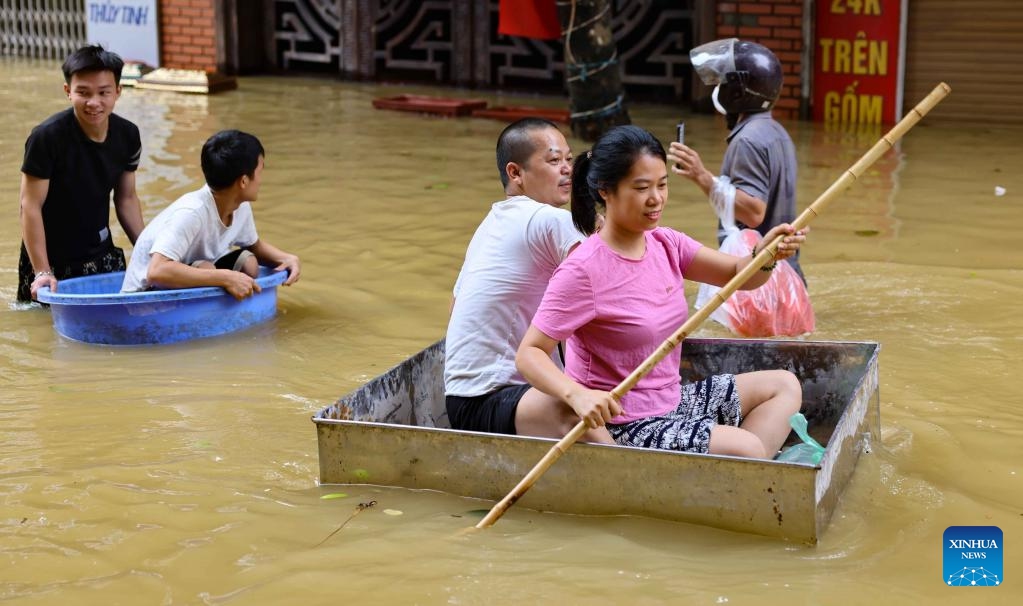 People used different paddling tools to move to safe areas in Gia Lam District, Hanoi, Vietnam, Sept. 12, 2024. Typhoon Yagi and the consequent landslides and floods have left 226 dead and 104 missing in Vietnam as of Thursday afternoon, the Ministry of Agriculture and Rural Development announced. (Photo: Xinhua)