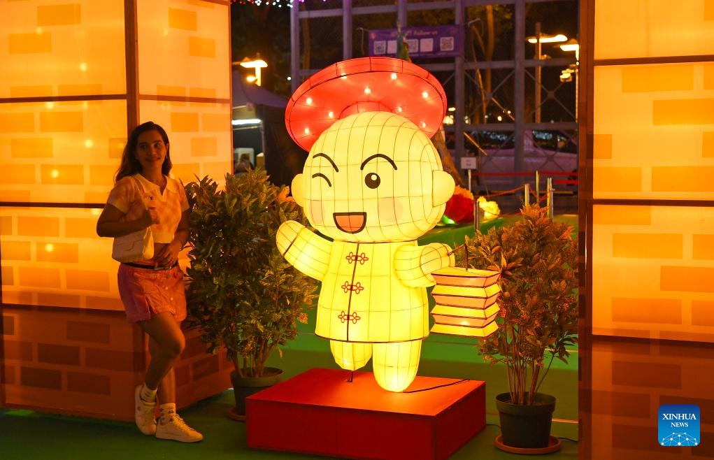 A woman poses for photos at a lantern fair marking the upcoming Mid-Autumn Festival and National Day at Victoria Park in Hong Kong, south China, Sept. 12, 2024. (Photo: Xinhua)