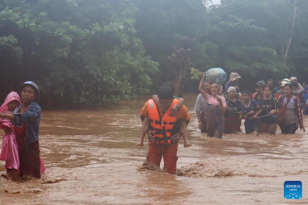 People wade through a flooded area in Tatkon Township, Nay Pyi Taw, Myanmar, Sept. 12, 2024. (Photo: Xinhua)