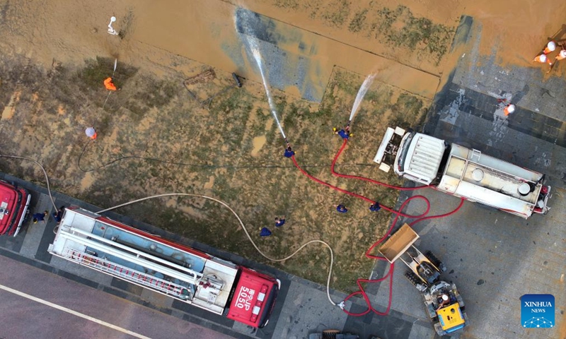 An aerial drone photo taken on Sept. 15, 2024 shows workers clearing silt at the riverside of Yongjiang River in Nanning, south China's Guangxi Zhuang Autonomous Region. Nanning has undergone the most severe flood situation since 2001 after Typhoon Yagi passed by the region on Sept. 12. (Photo: Xinhua)