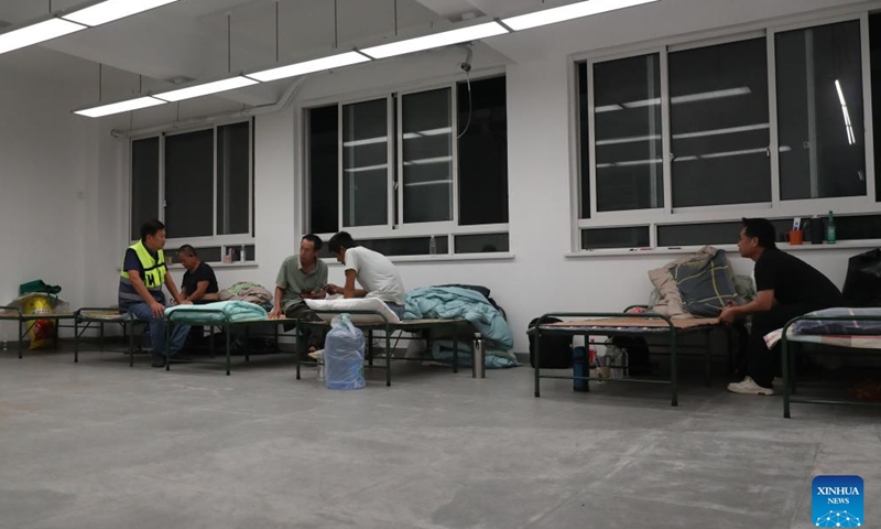 A staff member (L) talks with workers at a temporary relocation site in Pudong, east China's Shanghai, Sept. 15, 2024. (Xinhua/Fang Zhe)