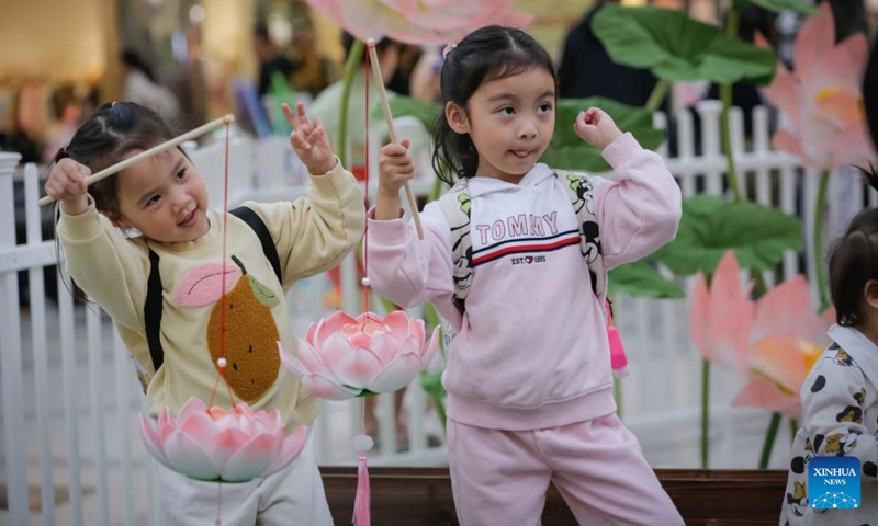 Children pose for photos with lanterns during a Chinese Mid-Autumn Festival celebration event at Lansdowne Centre in Richmond, British Columbia, Canada, Sept. 14, 2024. (Photo: Xinhua)