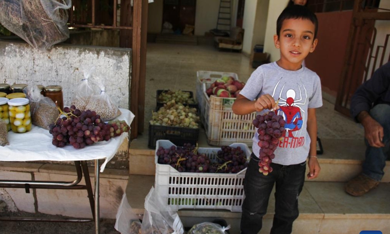 A boy shows grapes during a grape festival in Rashaya al-Wadi, Lebanon, on Sept. 14, 2024. (Photo: Xinhua)