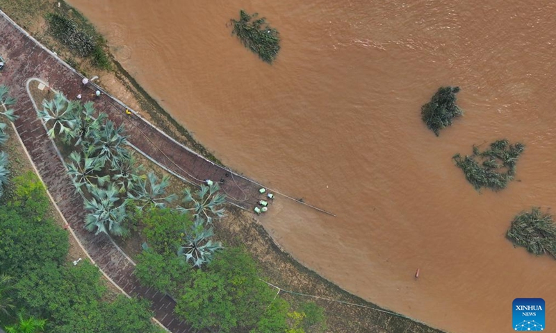 An aerial drone photo taken on Sept. 15, 2024 shows workers clearing silt at the riverside of Yongjiang River in Nanning, south China's Guangxi Zhuang Autonomous Region. Nanning has undergone the most severe flood situation since 2001 after Typhoon Yagi passed by the region on Sept. 12. (Xinhua/Huang Xiaobang)