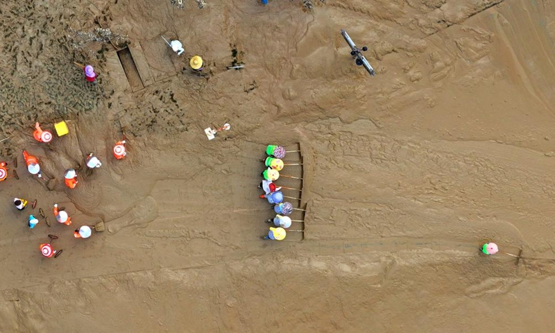 An aerial drone photo taken on Sept. 15, 2024 shows workers clearing silt at the riverside of Yongjiang River in Nanning, south China's Guangxi Zhuang Autonomous Region. Nanning has undergone the most severe flood situation since 2001 after Typhoon Yagi passed by the region on Sept. 12. (Photo: Xinhua)