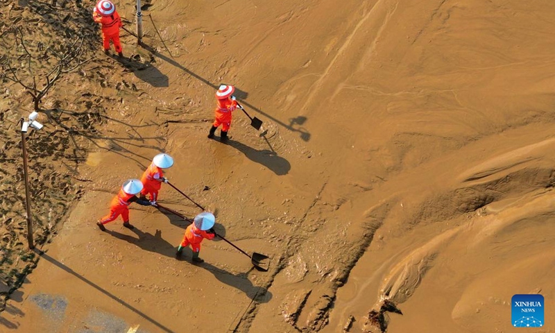 Workers clear silt at the riverside of Yongjiang River in Nanning, south China's Guangxi Zhuang Autonomous Region, Sept. 15, 2024. Nanning has undergone the most severe flood situation since 2001 after Typhoon Yagi passed by the region on Sept. 12. (Photo: Xinhua)