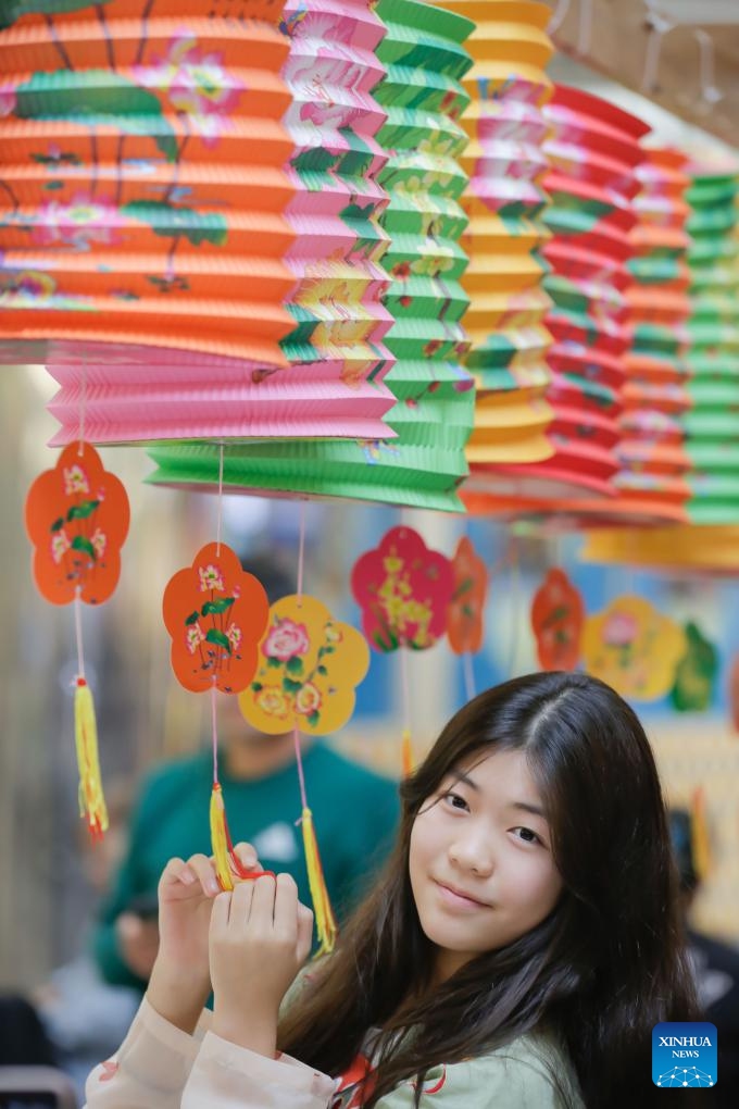 A girl poses for photos with lanterns during a Chinese Mid-Autumn Festival celebration event at Lansdowne Centre in Richmond, British Columbia, Canada, Sept. 14, 2024. (Photo: Xinhua)