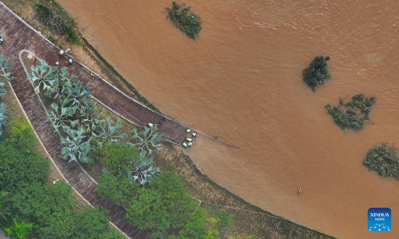 An aerial drone photo taken on Sept. 15, 2024 shows workers clearing silt at the riverside of Yongjiang River in Nanning, south China's Guangxi Zhuang Autonomous Region. Nanning has undergone the most severe flood situation since 2001 after Typhoon Yagi passed by the region on Sept. 12. (Photo: Xinhua)