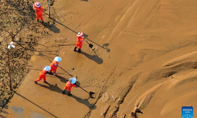 Workers clear silt at the riverside of Yongjiang River in Nanning, south China's Guangxi Zhuang Autonomous Region, Sept. 15, 2024. Nanning has undergone the most severe flood situation since 2001 after Typhoon Yagi passed by the region on Sept. 12. (Xinhua/Huang Xiaobang)