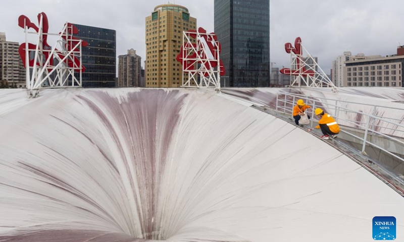 Workers check the fences on the rooftop of Shanghai Railway Station ahead of the landfall of Typhoon Bebinca in east China's Shanghai, Sept. 15, 2024. (Xinhua/Wang Xiang)