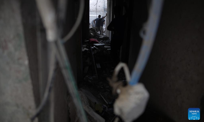 People inspect a destroyed building in the Nuseirat refugee camp, central Gaza Strip, on Sept. 16, 2024. Palestinian security sources told Xinhua on Monday that Israeli aircraft targeted a house in the Nuseirat refugee camp in the central Gaza Strip, killing at least 10.  (Photo: Xinhua)