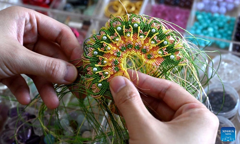 Chu Mengdan makes bead weaving handicrafts at an intangible cultural heritage experience hall in Luoyang City, central China's Henan Province, Sept. 12, 2024. (Photo: Xinhua)