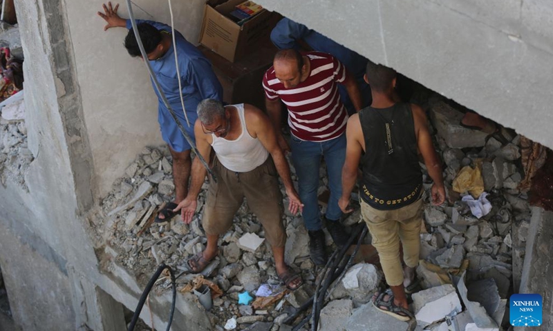 People inspect a destroyed building in the Nuseirat refugee camp, central Gaza Strip, on Sept. 16, 2024. Palestinian security sources told Xinhua on Monday that Israeli aircraft targeted a house in the Nuseirat refugee camp in the central Gaza Strip, killing at least 10.  (Photo: Xinhua)