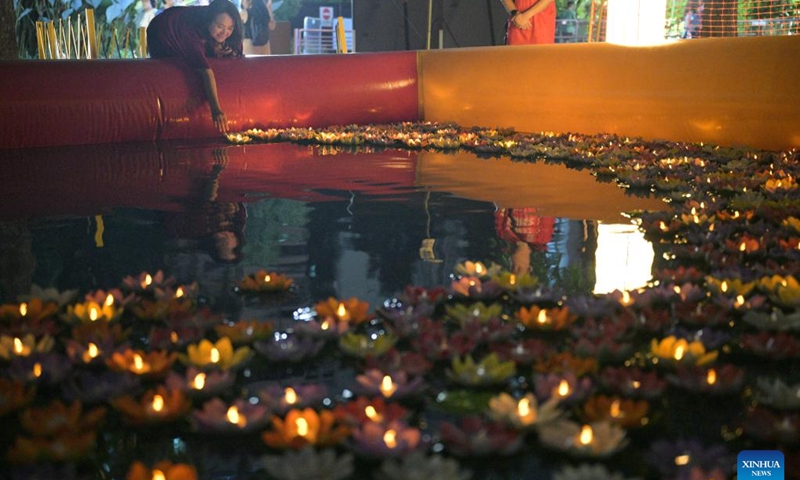 A woman releases a floating lantern during the Lights by the Lake event held to celebrate the Mid-Autumn Festival in Singapore on Sept. 16, 2024. (Photo: Xinhua)