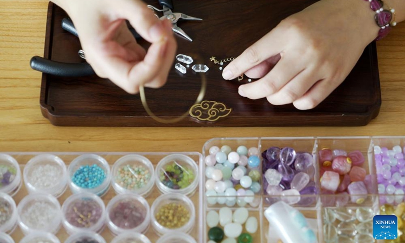 Chu Mengdan makes bead weaving handicrafts at an intangible cultural heritage experience hall in Luoyang City, central China's Henan Province, Sept. 12, 2024. (Photo: Xinhua)