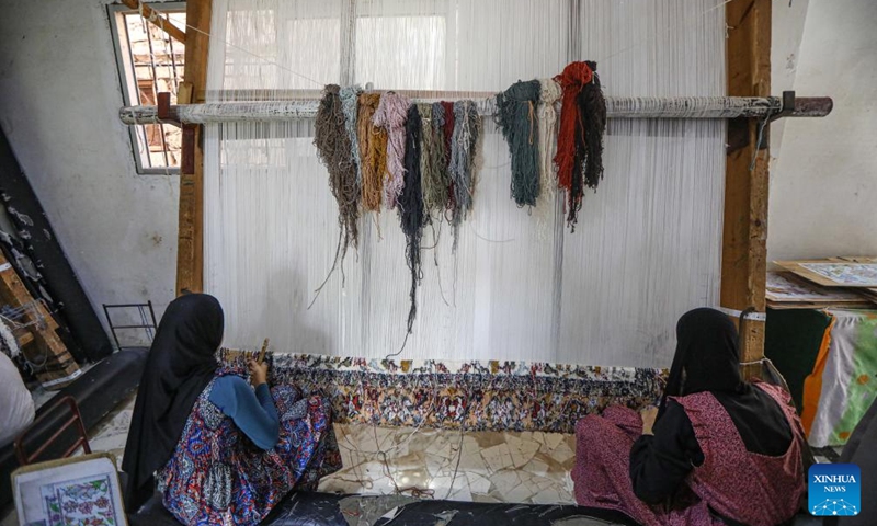 People weave a carpet with silk at Nagaa Awni village in Beheira governorate, Egypt, on Sept. 7, 2024. Nagaa Awni, located in Beheira governorate about 200 km from Cairo, used to be a village with houses made of mud-brick and straw, relying on external aid for food and blankets. Now, thanks to about eight years of efforts by the locals through various development projects, the village has transformed into a self-sufficient area. (Photo: Xinhua)