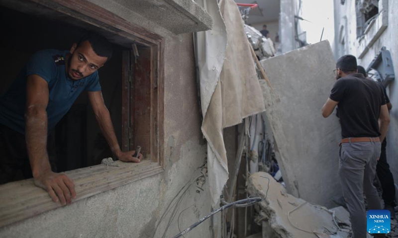 People inspect a destroyed building in the Nuseirat refugee camp, central Gaza Strip, on Sept. 16, 2024. Palestinian security sources told Xinhua on Monday that Israeli aircraft targeted a house in the Nuseirat refugee camp in the central Gaza Strip, killing at least 10.  (Photo: Xinhua)