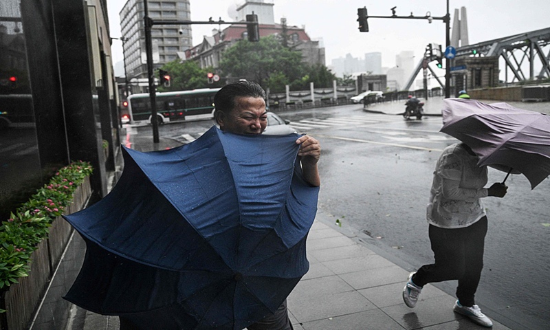 Pedestrians struggle with their umbrellas amid strong winds and rain from the passage of Typhoon Bebinca in Shanghai on September 16, 2024. Photo: VCG