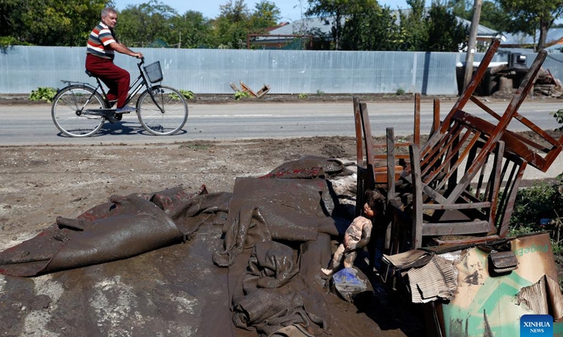 A man passes by destroyed furniture after floods in Galati County, Romania, Sept. 16, 2024. Galati County, Romania, is struggling to recover from the severe floods brought by Cyclone Boris on Saturday, which has claimed five lives and displaced over 250 residents.  (Photo: Xinhua)