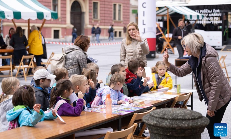 An event demonstrator teaches children the language of the deaf during the European Mobility Week in Ljubljana, Slovenia, on Sept. 16, 2024. Many Slovenian cities and towns hosted events promoting sustainable transport options to mark the European Mobility Week on Monday. (Photo: Xinhua)